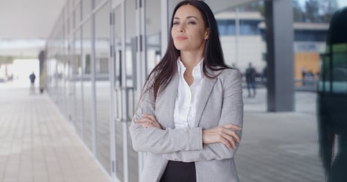 Confident Woman Stands in Front of Modern Building