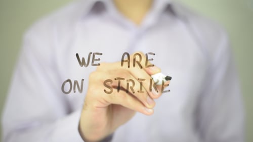 Hand Writing We Are On Strike Message on Glass