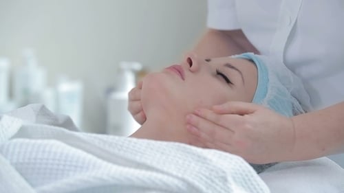 Woman Receiving a Relaxing Facial Massage at Spa