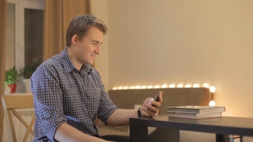 Adult Man Using Smartphone Indoors