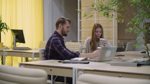 Two Staff Members Sit In The Office And Drinking Your Morning Coffee.