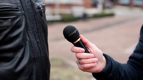 Hand Holding Microphone During City Interview