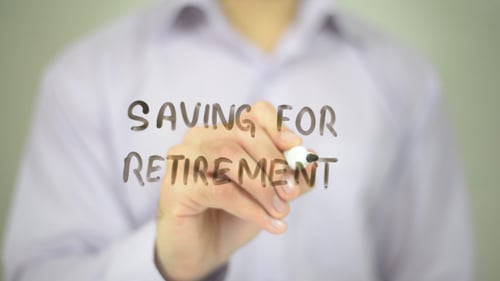 Hand Writes Saving for Retirement on Clear Surface