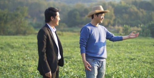 Farmer And Business Man Talking On Melon Field