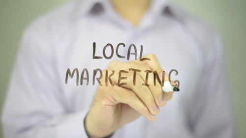 Arm Writes 'Local Marketing' on Clear Surface