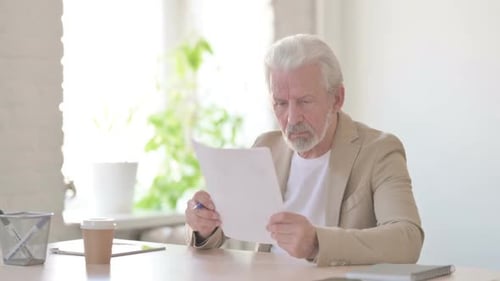 Man Reviews Documents at Bright Desk with Coffee