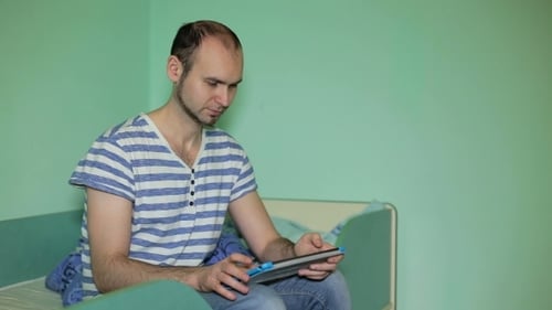 Young Adult Using Tablet While Sitting Indoors