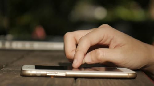 Hand Interacting With Mobile Cell Phone on Table