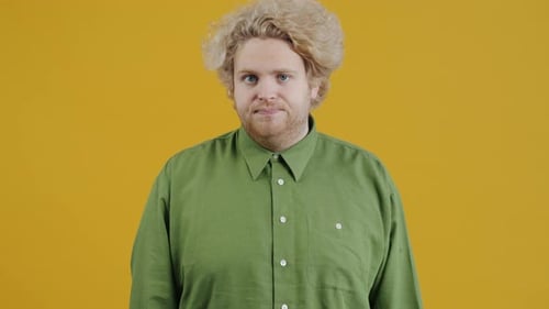 Man Gesturing No, Refusing Offer on Yellow Background