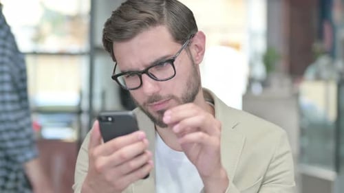 Man Using Smartphone in Modern Workplace