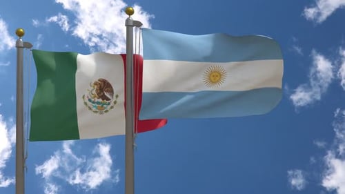 Waving Flags of Mexico and Argentina Against Blue Sky
