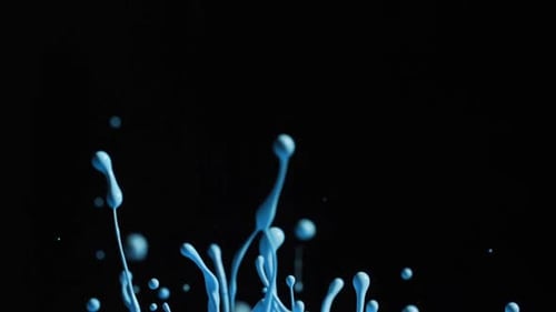 Peinture bleu vif éclaboussant avec des gouttelettes dans l'air