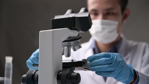 Scientist Working with Microscope in Lab