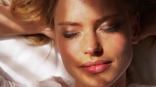 Mannequin au repos aux cheveux blonds dans un lit blanc