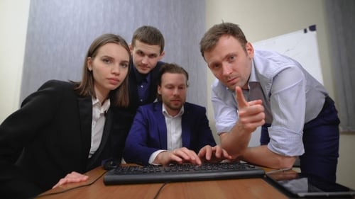 Team Collaborating Around Desk in Office