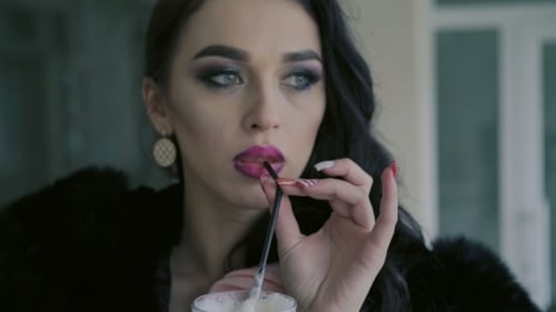 Glamorous Woman Sipping Drink in Cafe Close Up