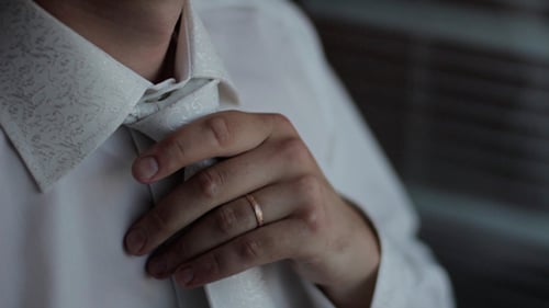 Man Adjusting Tie Close Up Indoors