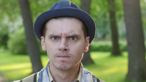 Portrait Of Boy In Hat Showing Grumpiness