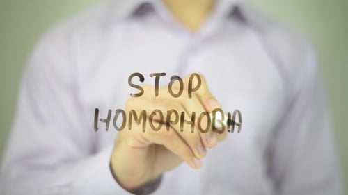 Writing Stop Homophobia Message on Clear Surface