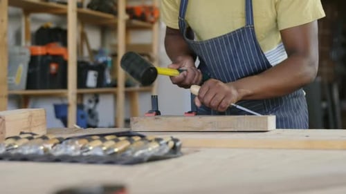 Carpenter Chiseling Wood With Mallet in Woodshop