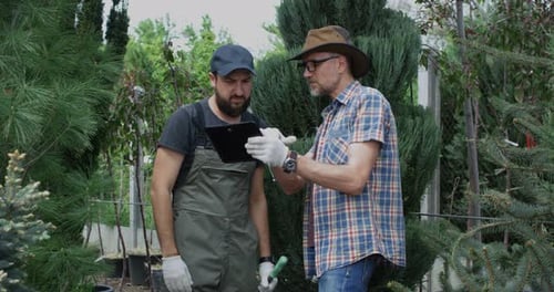Jardiniers utilisant une tablette et des ciseaux