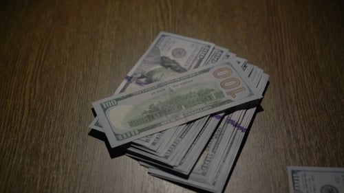 Ein Stapel von 100 Dollar fällt auf den Tisch