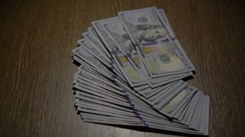 Ein Stapel von 100 Dollar fällt auf den Tisch