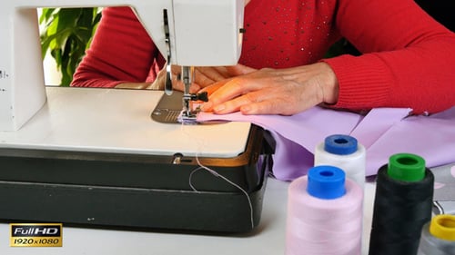 Woman Sews Lilac Fabric With Sewing Machine