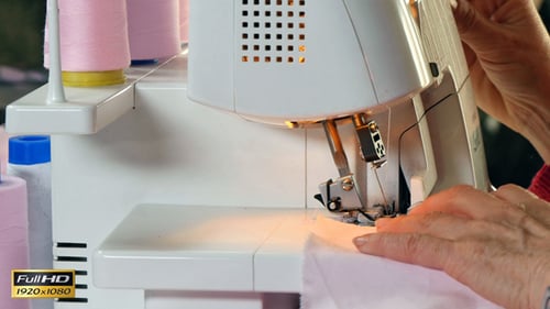 Seamstress Sews Clothes with her Over Lock Machine