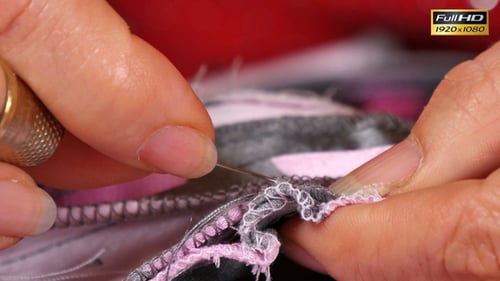 Hands Sewing Colorful Patterned Fabric with Needle