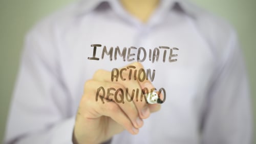 Immediate Action Required Written on Clear Glass