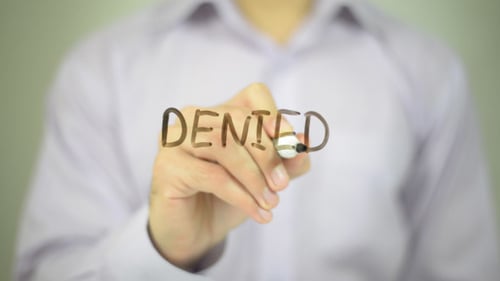 Hand Writes 'Denied' on Clear Surface
