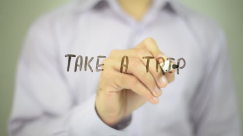 Hand Writing 'Take A Trip' on Clear Surface