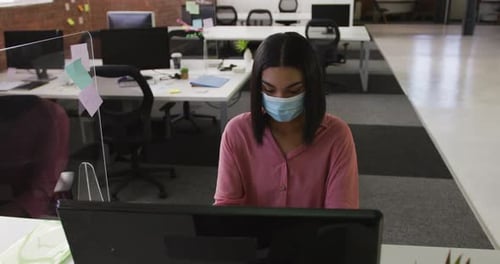 Woman in Mask Working at Computer in Office