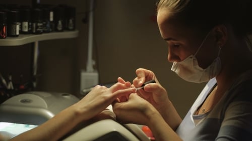 Manicurist Applying Nail Polish in a Nail Salon