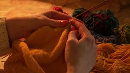 Hands Knitting with Needles and Yellow Yarn