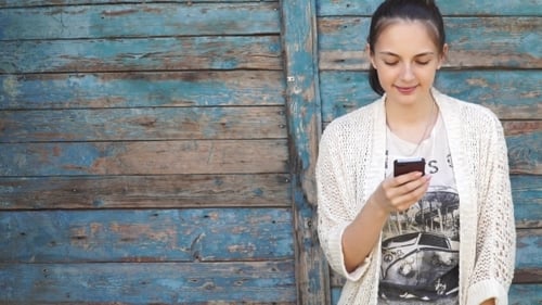 Woman Using Mobile Phone Against a Colorful Wall