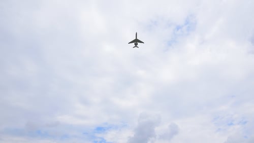 Jet Plane Flies Overhead Through Cloudy Sky