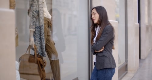 Young Woman Looking At a Shop Mannequin