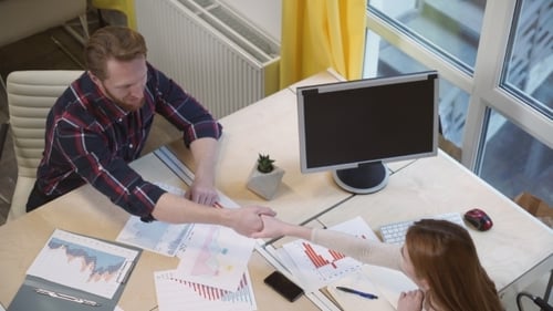 Business People Shaking Hands Over Data