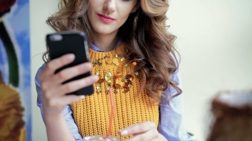Portrait Of Style Lady Sitting At The Table In Cafe Using Phone And Smiling