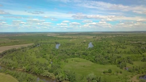 Flight Over Green Meadow, Forest and River in Spring
