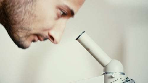 Man Lookig Through Microscope