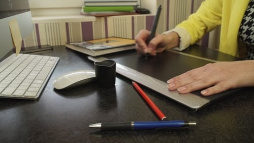 Woman Designs on a Tablet at Desk