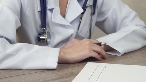 Der Doktor setzt seine Unterschrift in das Rezept