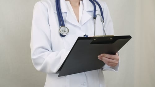 Doctor Standing füllt das Dokument