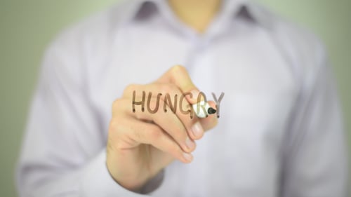Man Writes the Word Hungry With a Marker