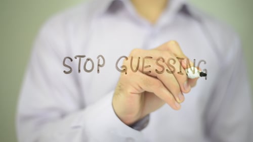 Hand Writing Stop Guessing on a Clear Surface