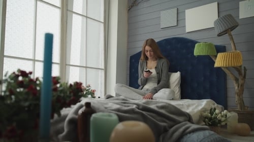 Woman Relaxing on Bed, Using Smartphone