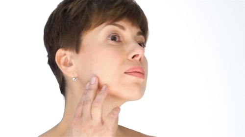 Woman Examines Skin on a White Background